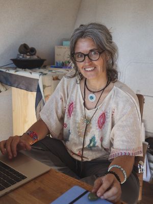 Celia sonriente en su oficina frente al ordenador